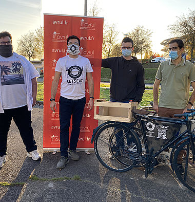 Les employés de l'entreprise LetsEat posent devant ESTER Technopole avec un kakémono et des vélos.