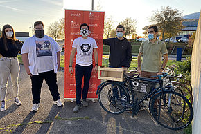 Les employés de l'entreprise LetsEat posent devant ESTER Technopole avec un kakémono et des vélos.
