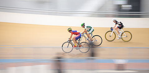 Trois cyclistes roulent sur la piste du Vélodrome Raymond Poulidor
