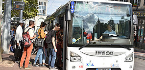 Des personnes montent dans un bus de Limoges Métropole qui est à l'arrêt.