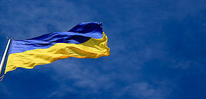Le drapeau de l'Ukraine flotte, su rue un ciel bleu.