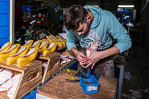 Un ouvrier de l'entreprise Danse Azur est dans son atelier et est en train de concevoir des chaussures de danse.