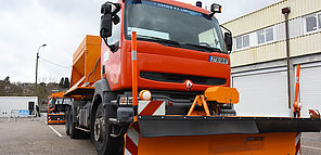 Un chasse-neige de Limoges Métropole est stationné sur le parking d'un entrepôt.