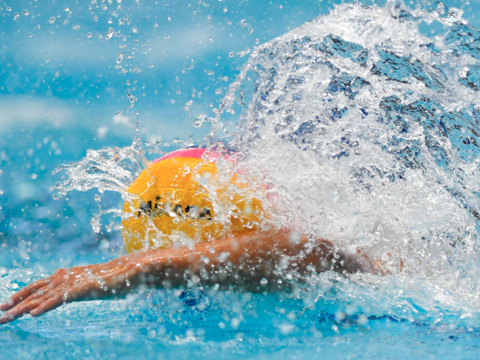 Un joueur de water-polo nage dans une piscine